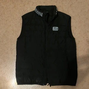 Ea7 Armani väst (Svart) - Storlek M, endast använd två gånger och i utmärkt skick. Perfekt för vår, sommar och höst. Originalpris: 2500 kr.