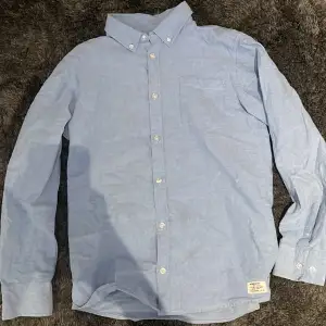 En blå skjorta storlek 160