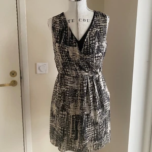 Spräcklig omlottklänning, stl M - Spräcklig omlottklänning i tunt material. Snygg på!!  Passar till alla typer av fester, sommar som vinter.  Djur- och rökfritt hem. 