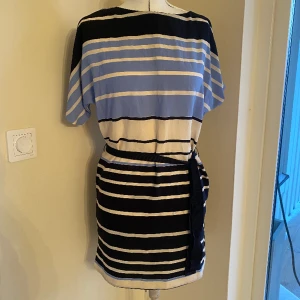 Randig klänning Mango, stl XS - Tunn och fin sommarklänning från MNG suit i fint skick. Band i midjan. Blå och vit, seglartema. Maritimt.   Passar dop, skolavslutningar, sommarfester etc. 