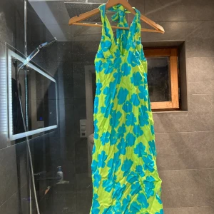 Färgglad klänning  - Säljer denna härliga klänning från Bershka som aldrig använts. (Prislapp kvar)  Har en öppen slits vid ryggen.