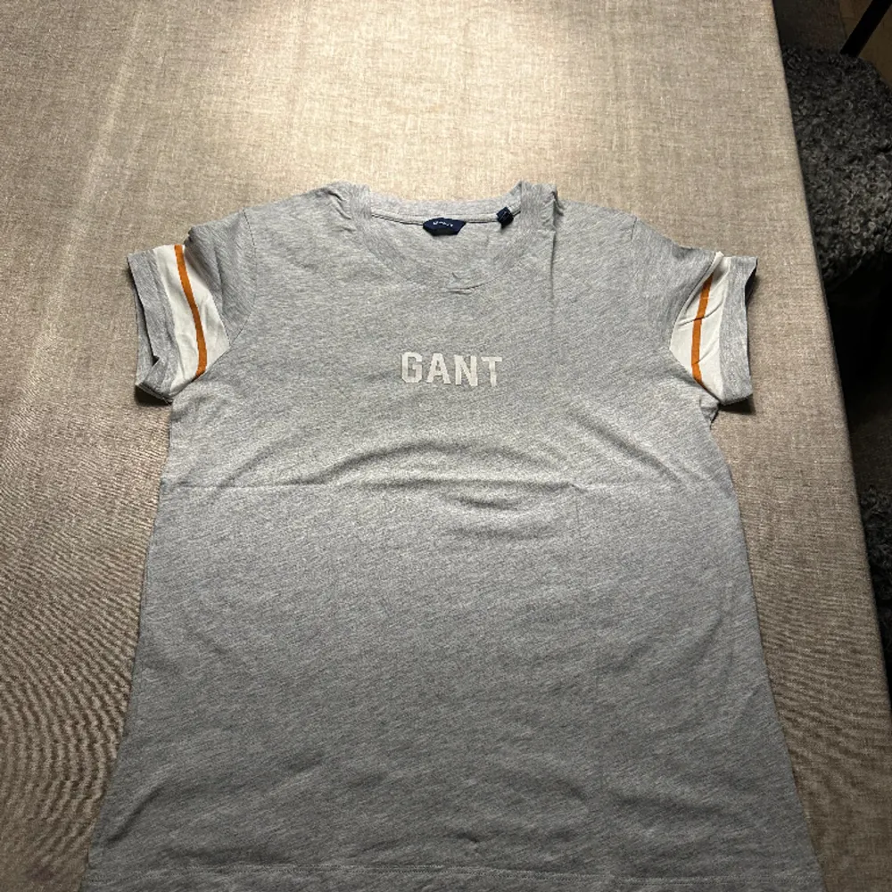 Gant T-shirt Grå med orange vita ränder på armarna. . T-shirts.