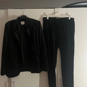 Kostymbyxor och en kavaj från Vila!  - Kostymbyxor och kavaj från Vila! Mycket glitter på! Använt den få gånger så det är i mycket god skick! Storlek i kavajen M och kostymbyxorna i L!