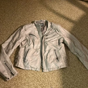 Skinn/bomber jacka - Beige skinn/bomber jacka. Livelo. Storlek 40. Fint skick. Vintage. Justerbar i sidorna. Dragkedja + knappar. Pris går att diskuteras. Fint skick. Skriv för fler bilder. 