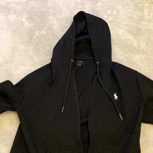 Ralph Lauren Zip Hoodie - Säljer min ralph lauren zip hoodie för att använder den inte längre har använt den några gånger 2-3. Färgen på den är Svart och storleken är Medium 