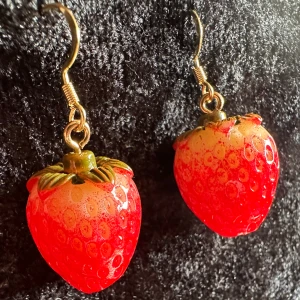 Söta örhängen m naturtrogna jordgubbar Cutie Cure  Smultron Vårkänsla Kawaii  - De här söta naturtrogna örhängena ger en känsla av sommaren.  Längd 4 cm, bredd knappt 2 cm. Örhängerna är nya, oanvända och handgjorda av mig.  Krokarna är nickelfria och hypoallergena, gubbarna i plast. Lätta och fina att bära. 