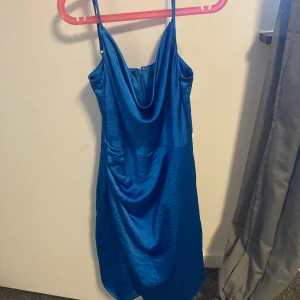 Blå klänning  - Wow wow wow! En blå riktigt snygg klänning från Gina Tricot. Knappt använd så den är i väldigt bra skick. Perfekt kalas/fest klänning och väldigt glansig. Väldigt fin blå färg, perfekt nu till sommaren! Axelbanden går att spänna in eller ut.