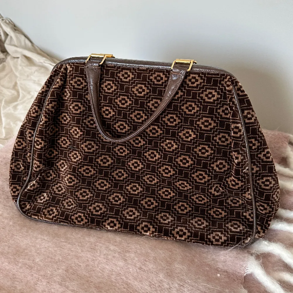 Vintage väska i brunt mönster med guldiga detaljer. Använd varsamt🫶🌷. Väskor.