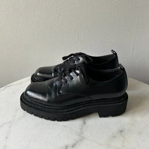 Loafers från Monki  - oafers från Monki. Använda några gånger, det enda som finns att anmärka på är en liten repa på sidan, dock inget man tänker på (går säkert att putsa till med skokräm).   Storlek: 38 Material: Vet ej, men förmodligen konstläder 