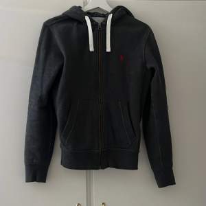 Superfin zip-up hoodie från Polo Ralph Lauren i en mörkgrå färg med rött märke. Storleken är Xs men passar även S. Nypris 2100, Mitt pris 499 men kan såklart diskuteras!❤️