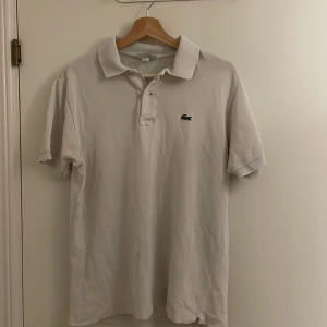 Lacoste Piké Tröja Vit - Säljer en snygga vit Lacoste piké för ändast 299kr. Den är i väldigt bra skick och passar riktigt bra. 