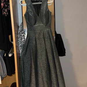 Silver klänning  - Fest/bröllopsklänning storlek S. Använd en gång, lång utan öppningar. Stretchig men samtidigt är den ganska tight från midjan ger en fin figur till kroppen. Klänningen har bröstkoppar så man behöver ej använda bh. 