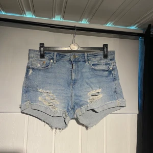 Jeansshorts  - Ljusblå jeansshorts med slitningar. Köpta på Cubus, knappt använda 