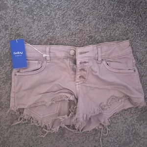 Rosa jeansshorts low waist  - Rosa jeansshorts ifrån Gina tricot köpta på sellpy. Köpt för 250 kr. De är i bra skick. Skulle säga att storleken stämmer. 37-38 cm i midjan.