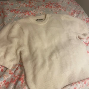 Stickad tröja - En superfin kortärmat stickad tröja med lite puffärm. Knappt använd så väldigt bra skick. Färgen är lite gräddvit💕💕