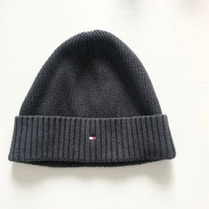 Tommy Hilfiger Mössa - Tommy Hilfiger Mössa Strl: ONE SIZE Färg: Mörkgrå  Passar tjejer och killar  Ordpris:439kr Fast Pris!