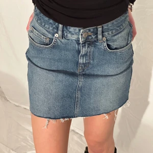 minidenimkjol - mellanblå denim kjol med slitningar. Ganska stretchig  och kortare i modellen, passar xs-s tjejen på bilden har i vanliga fall xs