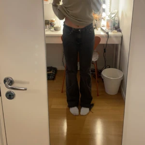 Svarta mid rise jeans - Fina svarta mid rise jeans från gina tricot med ett hål på ena knät. 