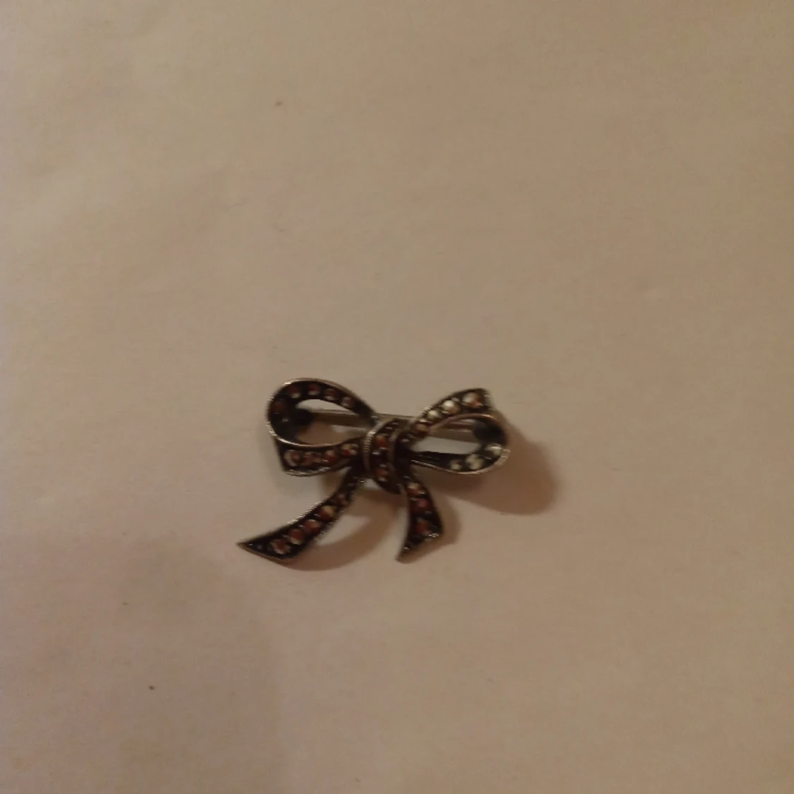 Brosch silverfärgad mönstrad markasiter . - 90