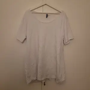En vit T-shirt i storlek XL. Använd som klänning.