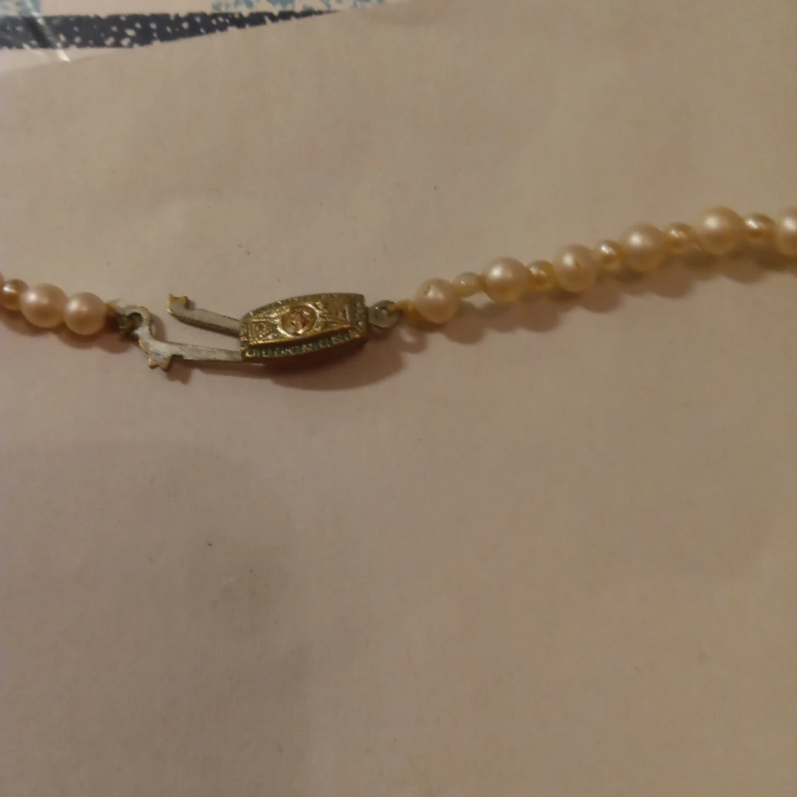 Pärlcollier med vita pärlor och lås med vit sten . - 91