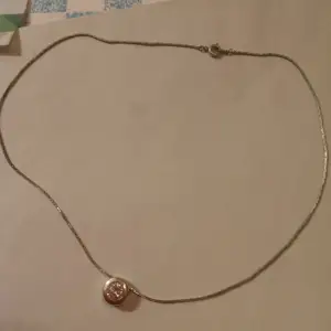 Halsband med hänge och liten vit sten .
