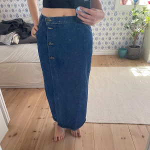 Jeanskjol - Lång jeanskjol köpt på Beyond Retro. Mid/low-waist. Passar mig som har 36 cm från höft till höft. Skriv för fler bilder/mått!