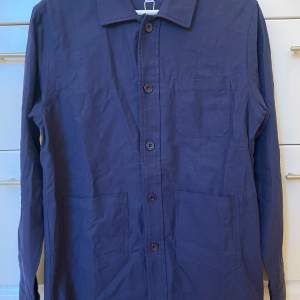 NY S & T Studios overshirt navy, storlek XS, ordinarie pris 1295. Klassisk och tidlösa jacka, tillverkad av högkvalitativa material. Perfekt balans mellan stil och funktionalitet. Med sina välplacerade detaljer och avslappnade passform skapar den en 