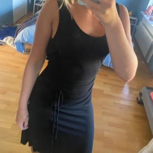 Svart klänning från Filippa K - Svart klänning med snöre i midjan från Filippa K. Sparsamt använd. Sann till storlek. 