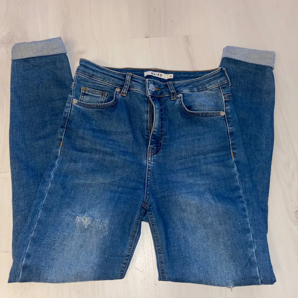 Ett par jeans från NA-KD med slitningar storlek S (Högmidjade)  Lyckas inte finna några anmärkningar utöver slitningarna som modellen ska ha. Jeans & Byxor.