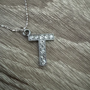 Halsband med bokstav - Ett super fint halsband med bokstaven T. Den är i mycket bra skick. Skriv för mer frågor och pris kan diskuteras 🩷