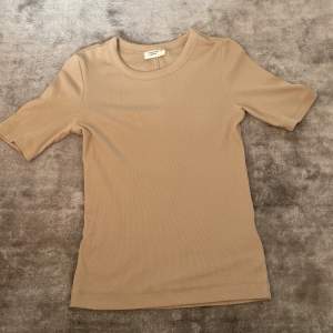 En beige t-shirt från Gina tricots basically basics plagg i strl xs🫶🏻