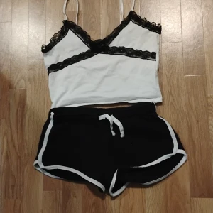 Linne och korta shorts i storlek s-m - Vitt linne med svart spets, svarta shorts med vita ränder, i storlek s-m  250 kr totalt