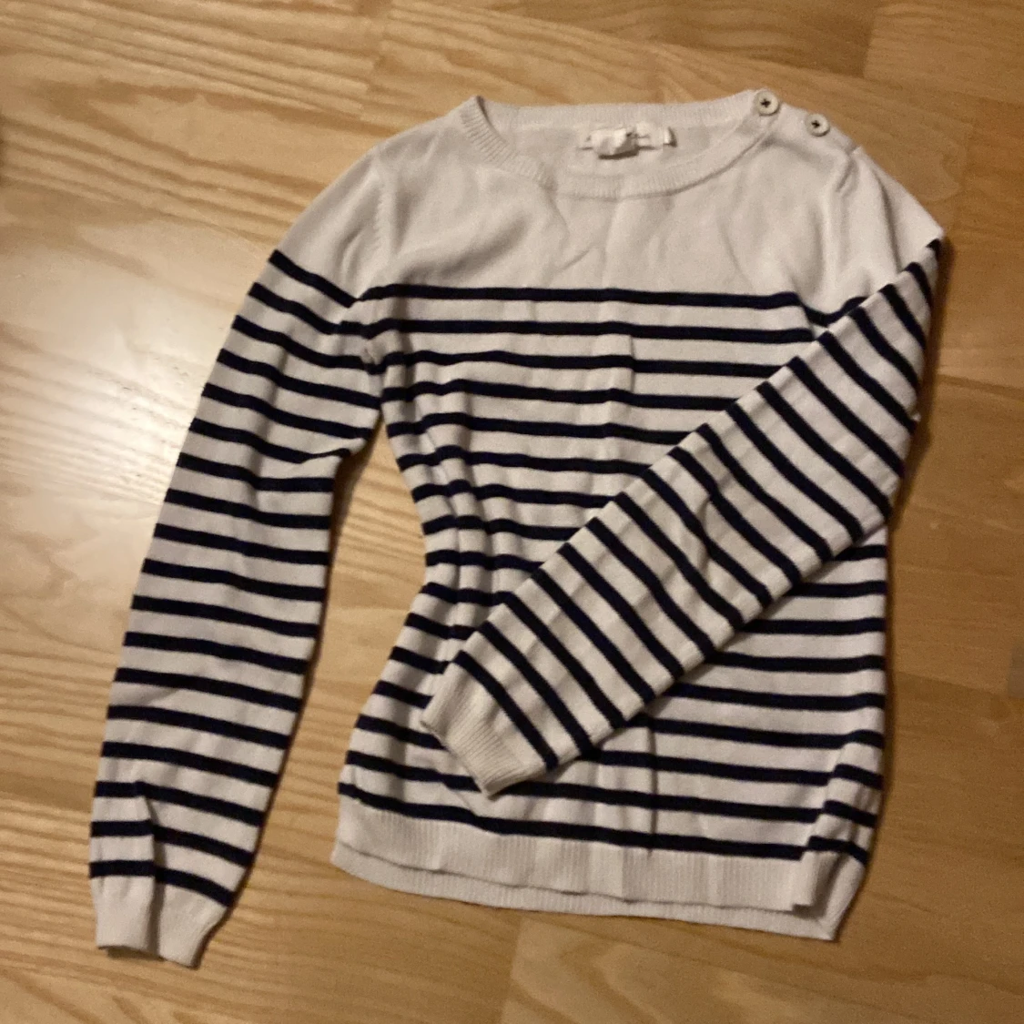 Randig stickad tröja med knappar på axeln