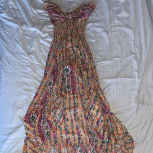 Fin mönstrad lång klänning - Lång mönstrad klänning som e längre där bak