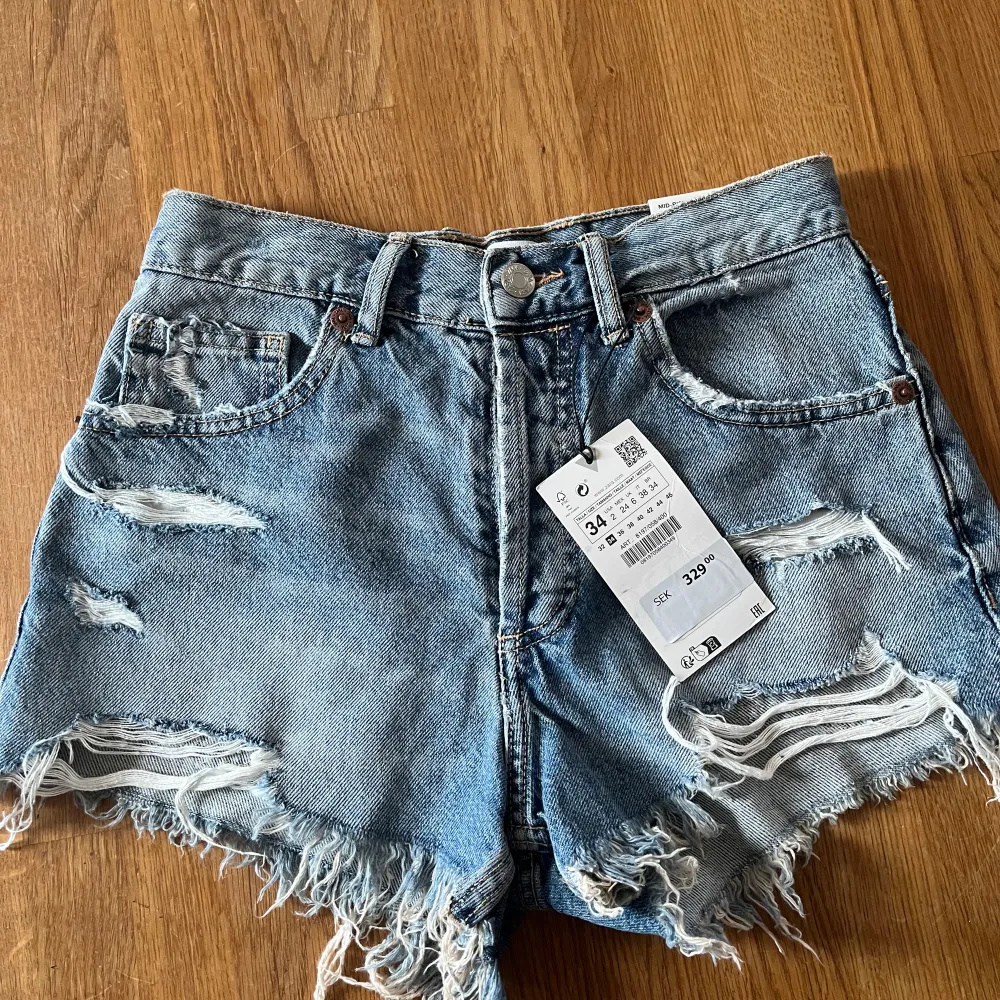 säljer mina ljusblåa mid rise jeansshorts från zara som är helt oanvända och lappen sitter kvar!  dem är i stolek 34. Shorts.