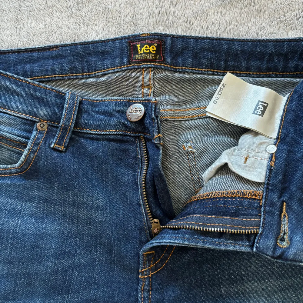 Detta är min brors mörkblåa jeans av märket Lee som han har vuxit ur. Jeansen är mjuka, sköna och bekväma med stretch i sig. Slitage framgår av fotona. Notera att jeanstyget är lagat under en jeansficka.. Farkut & Housut.