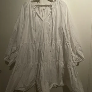 Klänning - Vit klänning med lös passform. Skönt och luftigt bomullstyg. Går ungefär till mitten av låren på mig som är 165 cm. Endast provad men tyvärr aldrig använd. 