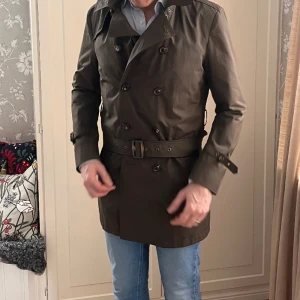 Trenchcoat från SAND	 - Säljer en trenschcoat från SAND. "mannen på bilden" är 188 cm lång och jag tycker den är i minsta laget för mig. är du 180 cm är den perfekt.