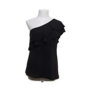 One shoulder topp  - Svart one shoulder topp från H&M med volang. Storlek M. Endast provad. Ny med lappen kvar. Slutsåld.