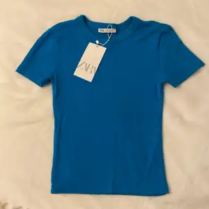 Helt oanvänd blå tight ribbad t-shirt från zara. Passar de som har xs och s, köparen står för frakt. Tar emot prisförslag💗
