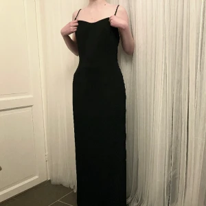 Svart långklänning  - Vintage svart långklänning från New York. Den är i jättebra skick med snörning i ryggen. Jag är 168 cm och den går ned till golvet för mig.