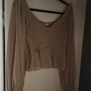 Blus - Fin blus, v-ringad. Beige/rosa med prickar. 