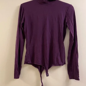 Plommonfärgad body - Säljer denna snygga plommonfärgade body som jag fick som gåva. Sparsamt använd och i superbra skick. Passar som S/M. Säljer en likadan fast i olivgrön i annan annons.