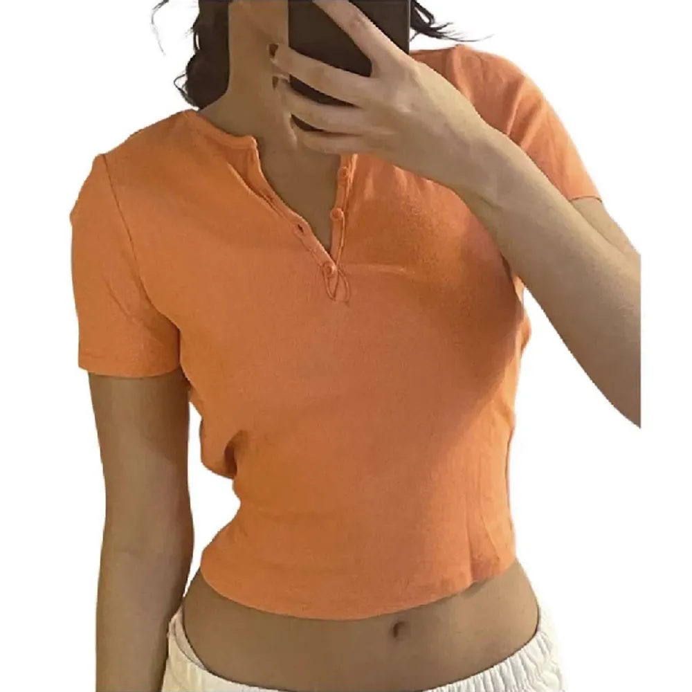 Väldigt fin orange t-shirt med knappar . T-shirts.
