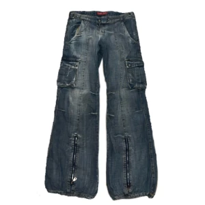 Lowrised jeans - Jätte snygga low rised jeans i en blå-grå färg med fickor på sidorna!! Noll skador   midjemått 40cm rakt över, ytterbenslängd 100cm, ben öppning ca 26cm  