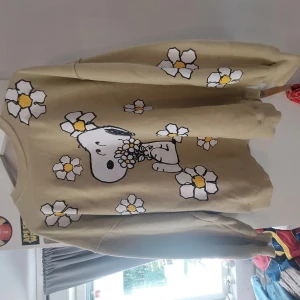 Snobben - En tröja med snobben på och en massa fina blommor. Det är en fin beige/grön färg som passar till de mästa. Har används några gånger men inte tillräckligt 