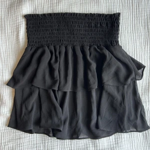 Chelsea volangkjol - Säljer denna bedårande volangkjol från märket Chelsea som också går att använda som topp (se bild 3)! Den är nästintill oanvänd och därav inga defekter och det finns inga tecken på användning. Nypris: 449kr.