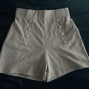 Shorts - Säljer dessa shortsen med guld detaljer från H&M. Använda 1 gång. Säljer pga för små för mig. De är i fint skick. Nypris 179kr mitt pris 75kr. Pris kan diskuteras.