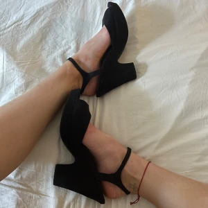 Klackar - Tjocka klackar från Åhléns.  Lite 70 tals stil med en låg platå och bred klack. Dom är gjorda i svart mocka och är köpta på tidiga 2010 talet av min mamma. Tyvärr är de för stora för mig 💕 Skriv för fler bilder. Pris kan diskuteras ✉️